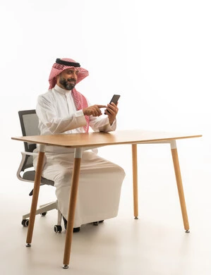 Saudi Man Using Smartphone at Office Desk