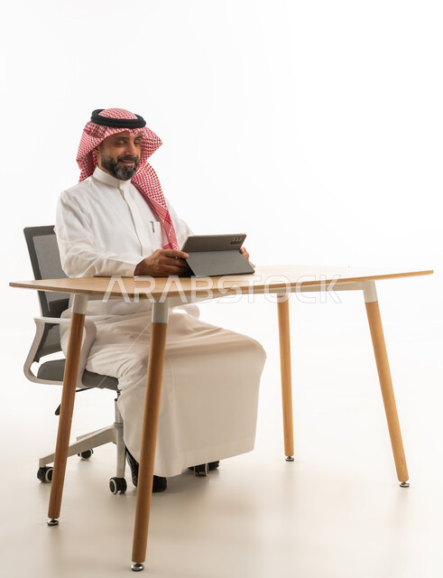 Saudi Businessman with Tablet at Desk White Background