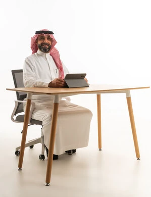 رجل أعمال سعودي يستخدم جهاز لوحي في مكتب حديث