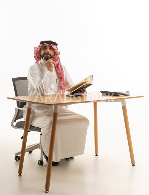 Saudi Man in Traditional Thobe Thinking with Book