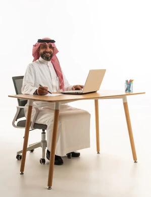 Saudi Businessman Using Laptop at Office Desk