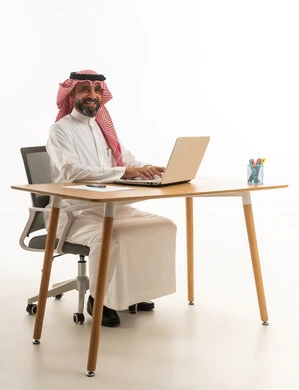 Saudi Businessman Using Laptop at Office Desk