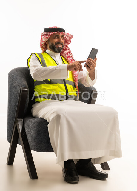 Saudi Engineer in Safety Vest Using Smartphone