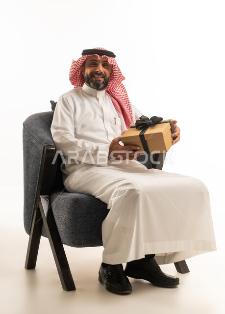 Saudi Man in Traditional Thobe Holding Gift Box