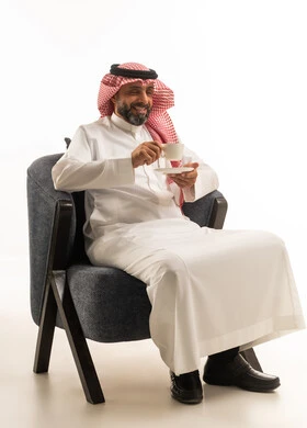 Saudi Man in Traditional Attire Drinking Coffee