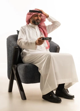رجل سعودي يلعب ألعاب الفيديو بتعبير محبط