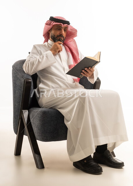 Saudi Man in Traditional Dress Reading a Book