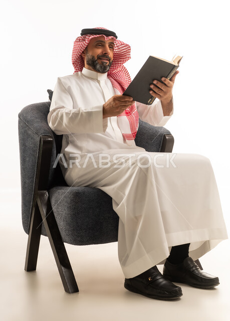 Saudi Man in Traditional Dress Reading Book