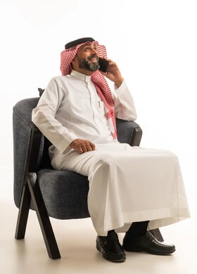 رجل سعودي يتحدث بالجوال بالثوب التقليدي