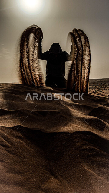 صورة إبداعية ظلية لرجل يحمل بيدة رمال ينثرها في الهواء ، الكثبان الرملية الصحراوية في المملكة العربية السعودية ، الرمال الناعمة ، الطبيعة الصحراوية في السعودية وقت الشروق