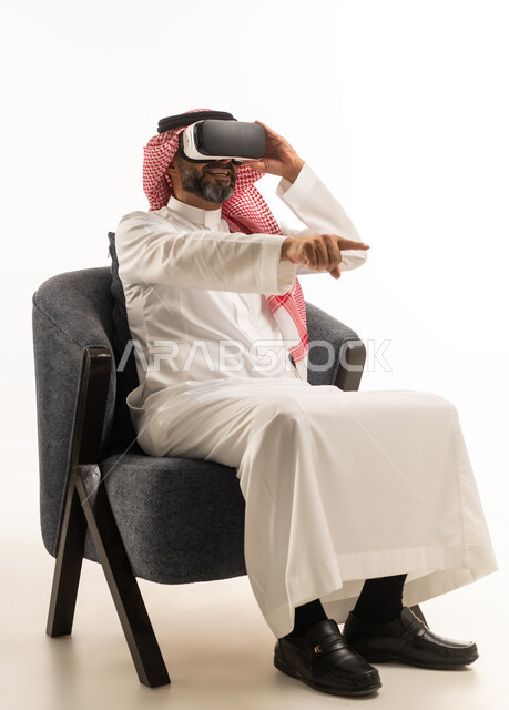 رجل سعودي يرتدي نظارة واقع افتراضي ويشير للأمام