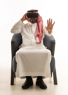 رجل سعودي يرتدي نظارة واقع افتراضي بخلفية بيضاء