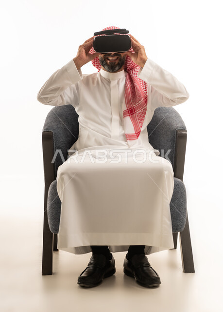 رجل سعودي بالزي التقليدي يستخدم نظارة الواقع الافتراضي