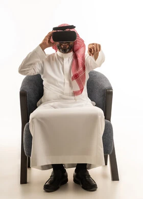 Saudi Man Wearing VR Headset Sitting in Armchair