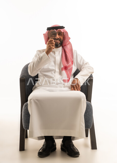 Saudi Man Holding Magnifying Glass on White Background