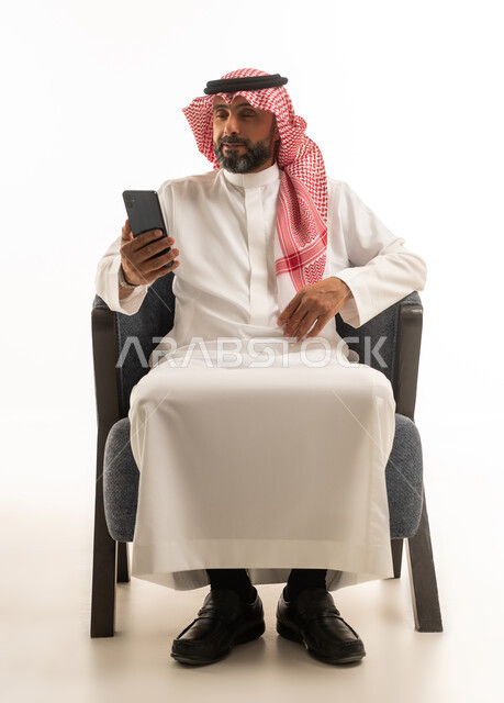 Saudi Man in Traditional Thobe Using Smartphone
