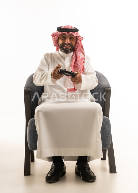 رجل سعودي يلعب ألعاب الفيديو بالزي التقليدي