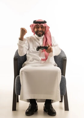 رجل سعودي يلعب ألعاب الفيديو ويحتفل بالفوز