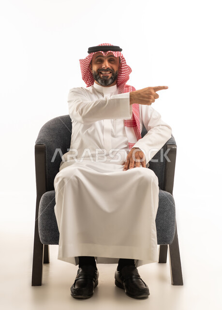 رجل سعودي بالزي التقليدي يشير بيده