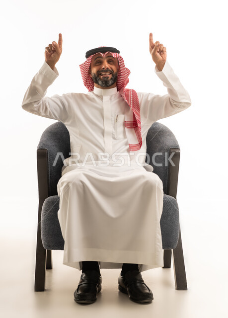 رجل سعودي بالزي التقليدي يشير إلى الأعلى