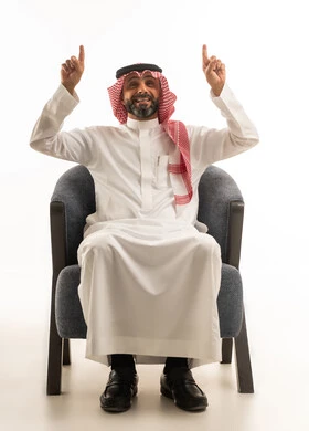 رجل سعودي بالزي التقليدي يشير إلى الأعلى