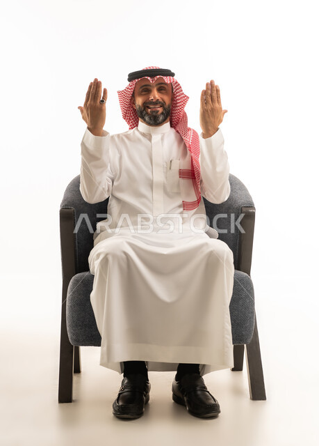 Saudi Man in Traditional Dress Praying in Armchair