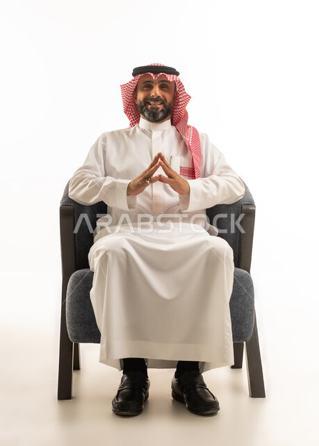 Saudi Businessman in Traditional Thobe Sitting on Armchair