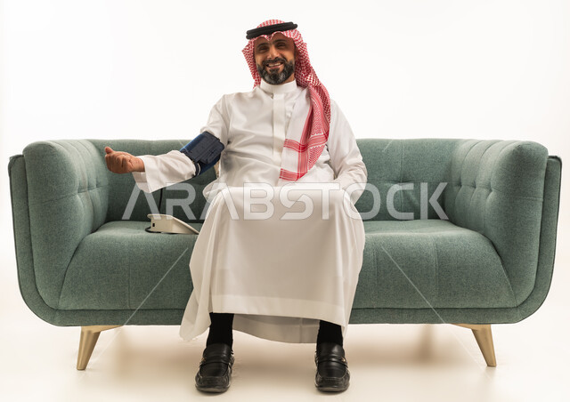 رجل سعودي يقيس ضغط الدم على أريكة خضراء