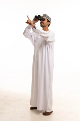 رجل عماني يستخدم المنظار على خلفية بيضاء