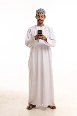 Omani Man in Traditional Dress Using Smartphone