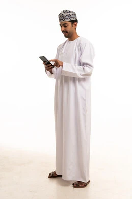 Omani Man in Traditional Dishdasha Using Smartphone