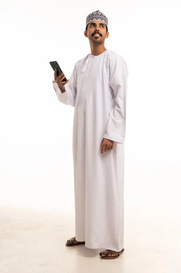 رجل عُماني بالزي التقليدي يمسك هاتف ذكي
