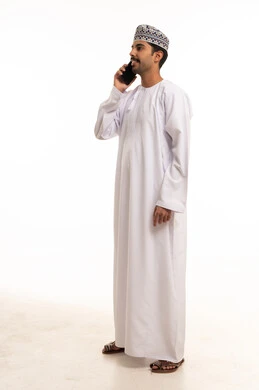 Omani Man in Traditional Dress Talking on Smartphone