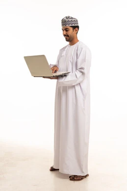 Omani Man in Traditional Dress Using Laptop