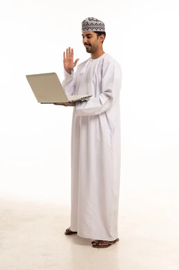 رجل عماني يحمل حاسوب محمول ويلوح في مكالمة فيديو