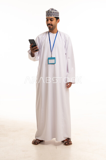 Omani Man in Traditional Dress Using Smartphone