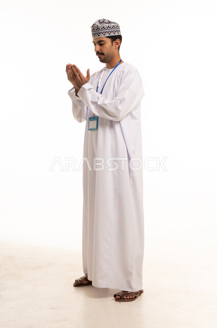 Omani Man Praying in Traditional Dress on White Background