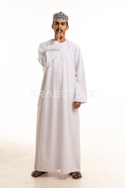 Omani Man in Traditional Dress Making Silence Gesture