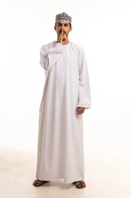 رجل عُماني بالزي التقليدي يشير بالصمت