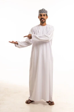رجل عماني بالزي التقليدي يشير بيده نحو كفه المفتوحة