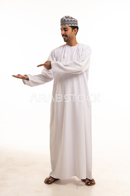 رجل عماني يشير بيده على خلفية بيضاء