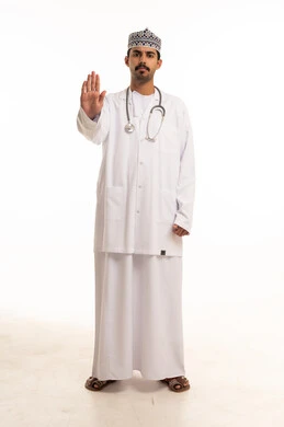 طبيب عُماني بالمعطف الأبيض يرفع علامة التوقف