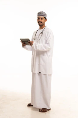 طبيب عماني يحمل جهازا لوحيا على خلفية بيضاء