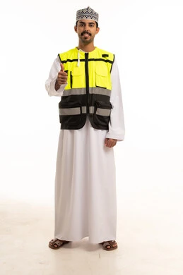 رجل عماني يرتدي سترة السلامة مع إيماءة الإبهام
