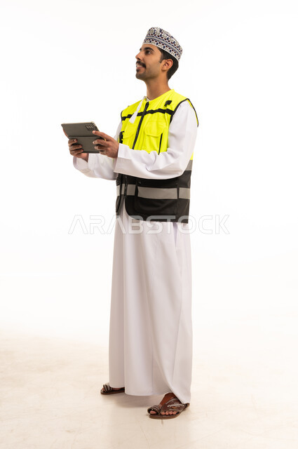 مهندس عماني بجهاز لوحي وسترة السلامة