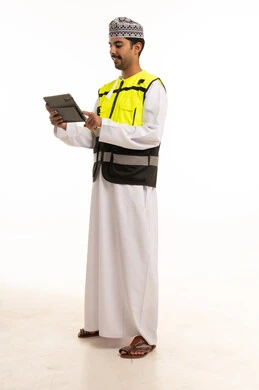 مهندس عماني مع جهاز لوحي بخلفية بيضاء