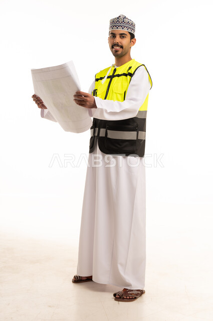 Omani Engineer Holding Construction Blueprint in Studio