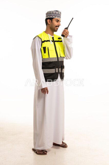 Omani Man in Safety Vest Using Walkie Talkie