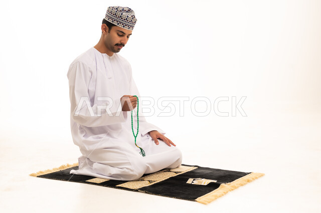 Omani Man Praying with Misbaha on White Background