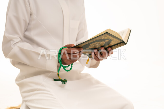 Saudi Man Reading Holy Quran with Prayer Beads
